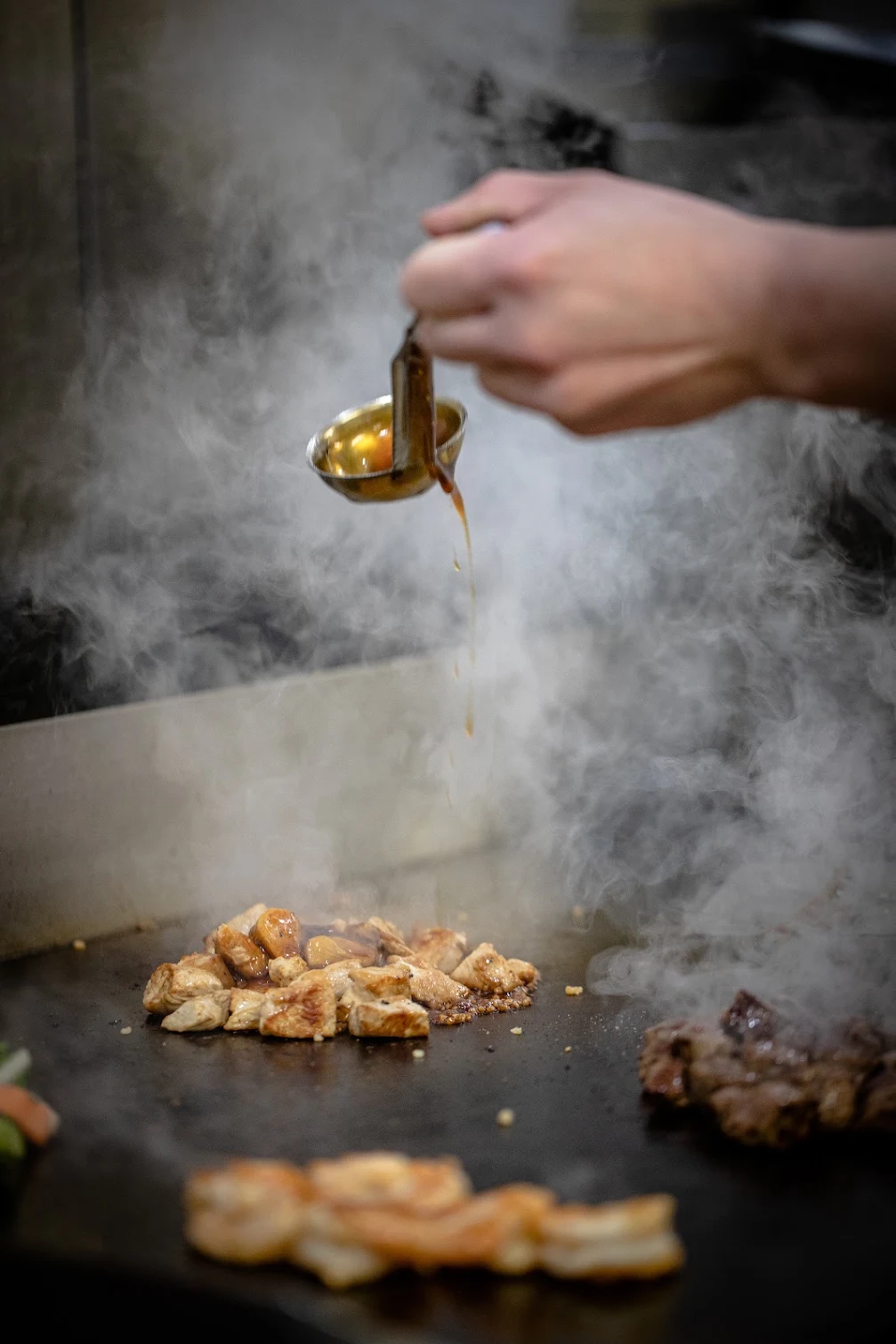 Sauce poured onto the hot hibachi grill
