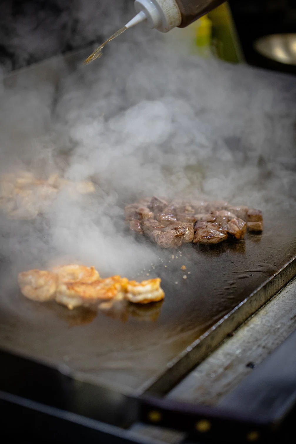 Steak and shrimp sizzling on the grill